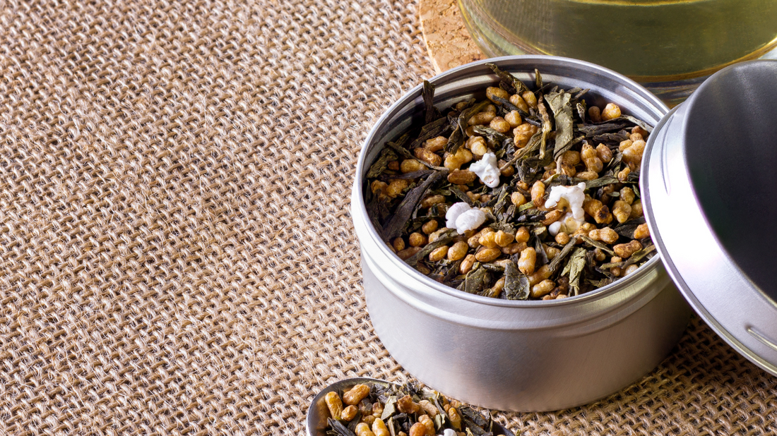 Tasse de Genmaicha, thé vert japonais mélangé à du riz grillé, posée sur une table en bois.